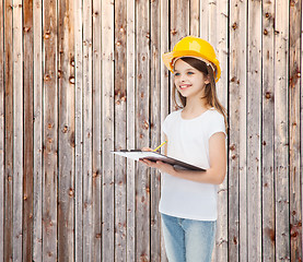 Image showing smiling little girl in hardhat with clipboard