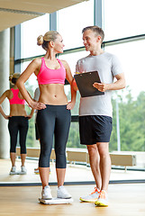Image showing smiling man and woman with scales in gym