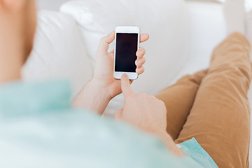 Image showing close up of man sitting with smartphone at home