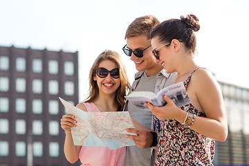 Image showing smiling friends with map and city guide outdoors