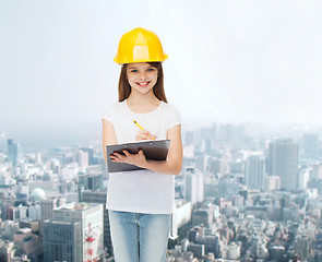 Image showing smiling little girl in hardhat with clipboard