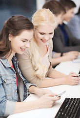 Image showing students with computer monitor and smartphones