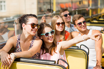 Image showing group of smiling friends traveling by tour bus