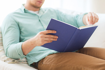 Image showing close up of man reading book at home