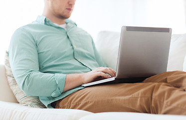 Image showing close up of man working with laptop at home