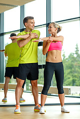 Image showing smiling man and woman exercising in gym