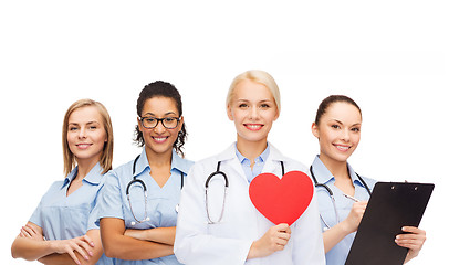 Image showing smiling female doctor and nurses with red heart