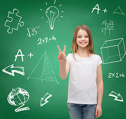 Image showing smiling little girl in white showing victory sign