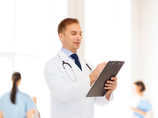 Image showing smiling male doctor with clipboard and stethoscope