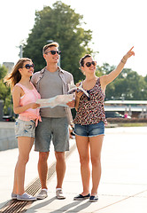 Image showing smiling friends with map and city guide outdoors