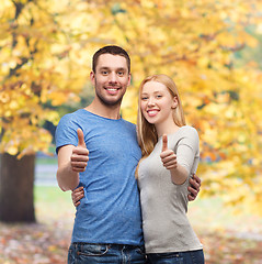 Image showing smiling couple showing thumbs up