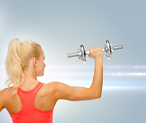 Image showing sporty woman with heavy steel dumbbell from back