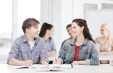 Image showing two teenagers with notebooks and book at school