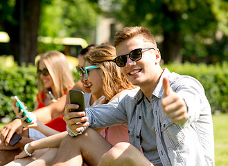 Image showing smiling man with smartphone showing thumbs up