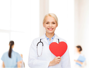 Image showing smiling female doctor with heart and stethoscope