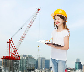 Image showing smiling little girl in hardhat with clipboard