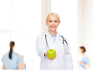 Image showing smiling female doctor with green apple