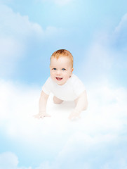 Image showing crawling smiling baby looking up