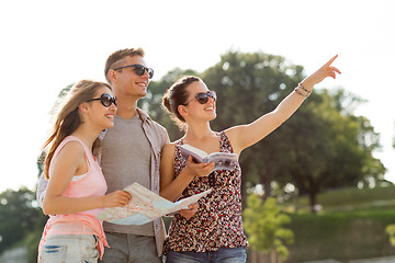 Image showing smiling friends with map and city guide outdoors