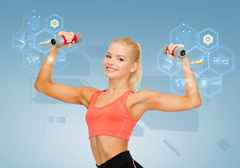 Image showing smiling beautiful sporty woman with dumbbells