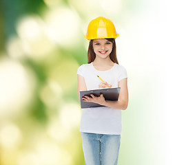 Image showing smiling little girl in hardhat with clipboard