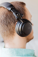 Image showing close up of man in headphones at home