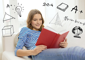 Image showing smiling teenage girl reading book on couch