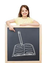 Image showing smiling little girl pointing finger to blackboard