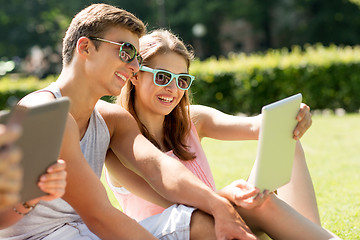 Image showing smiling friends with tablet pc computers in park