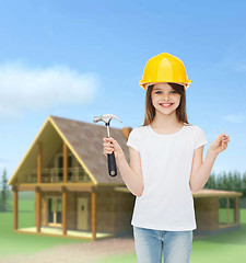 Image showing smiling little girl in hardhat with hammer