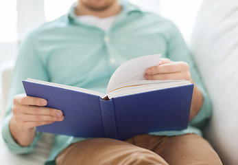 Image showing close up of man reading book at home