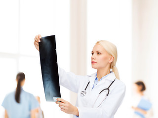 Image showing serious female doctor looking at x-ray