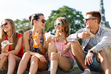 Image showing group of smiling friends sitting on city square