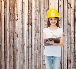 Image showing smiling little girl in hardhat with clipboard