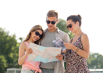 Image showing smiling friends with map and city guide outdoors