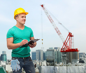 Image showing smiling man in helmet with clipboard