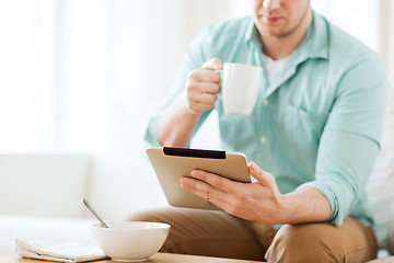 Image showing close up of man with tablet pc having breakfast
