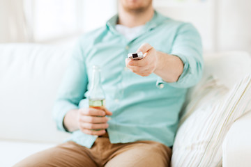 Image showing man with beer and remote control at home