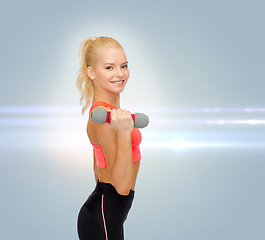 Image showing smiling beautiful sporty woman with dumbbell