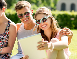 Image showing smiling friends with tablet pc computers in park