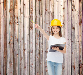 Image showing smiling little girl in hardhat with clipboard