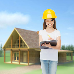 Image showing smiling little girl in hardhat with clipboard