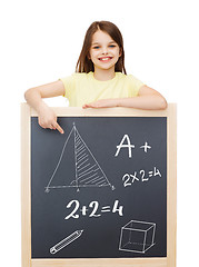 Image showing smiling little girl pointing finger to blackboard