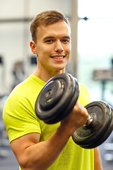 Image showing smiling man with dumbbell in gym