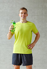 Image showing smiling man with bottle of water in gym