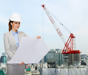 Image showing businesswoman in white helmet with blueprint