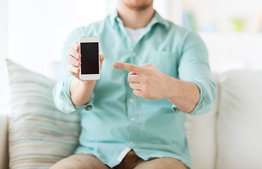 Image showing close up of man sitting with smartphone at home