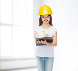 Image showing smiling little girl in hardhat with clipboard