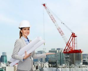 Image showing smiling architect in helmet with blueprint