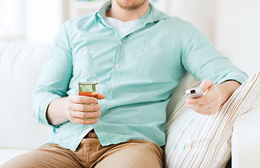 Image showing man with beer and remote control at home